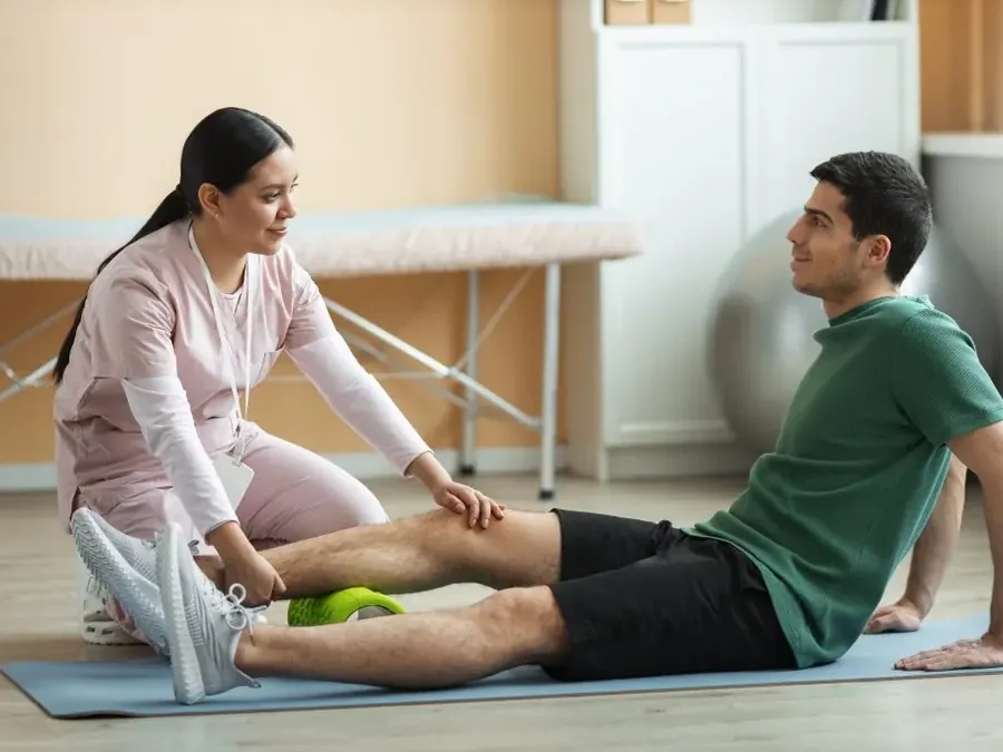 A physiotherapist guiding a patient through a leg exercise